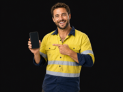 Happy tradesman holding a phone and pointing to it after a finance approval